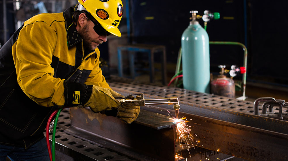 Person wearing ESAB gear while welding.