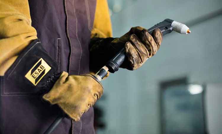 Welder wearing PPE and holding a Thermal Dynamics 1Torch