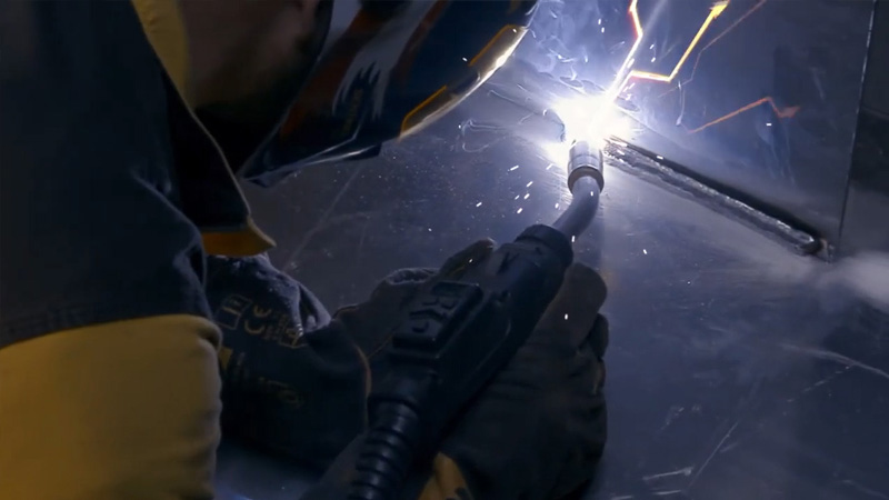 Push-pull MIG welding gun in action welding aluminum with bright arc.