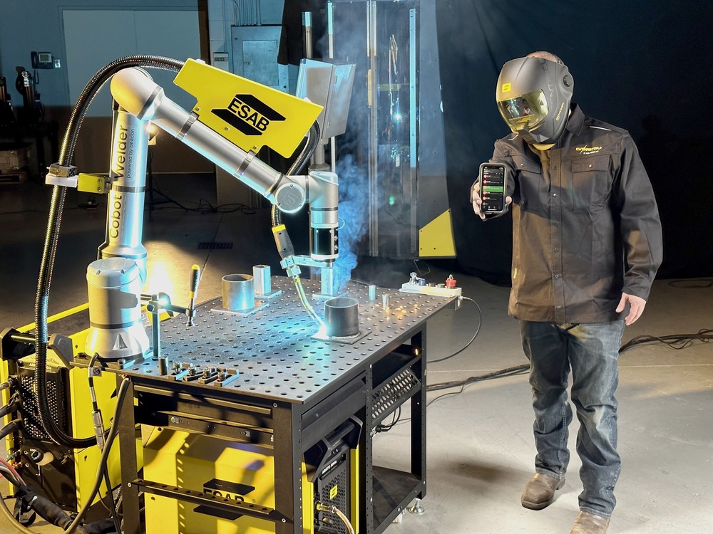 A welder using the app to control ESAB Cobot
