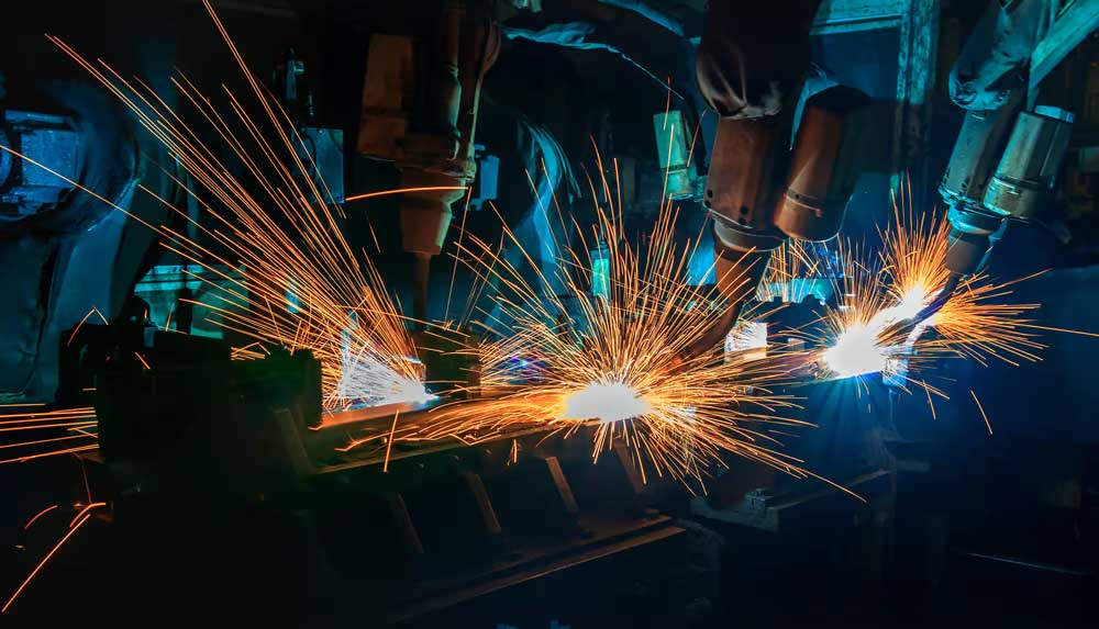 Robots are welding in factory.