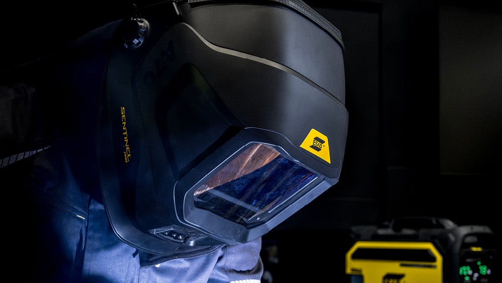 Close-up of a welder wearing Sentinel A70 Helmet with ESAB machine in background